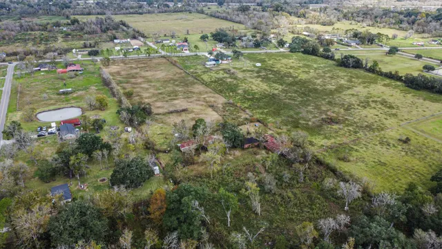 an aerial view of residential houses with outdoor space and trees