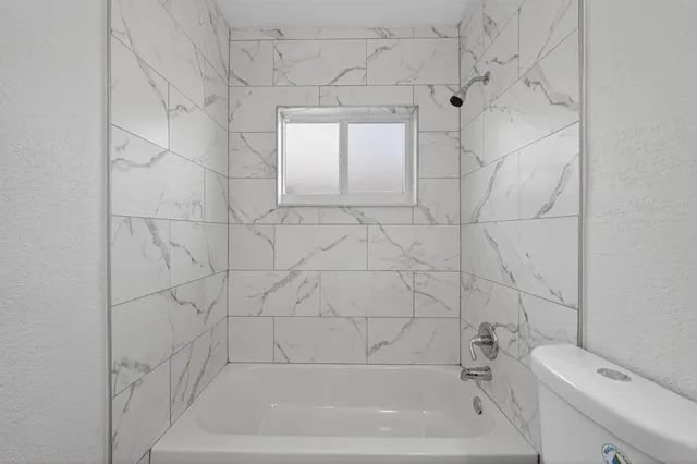 a bathroom with a bathtub and toilet