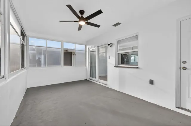 a view of a big room with wooden floor and windows