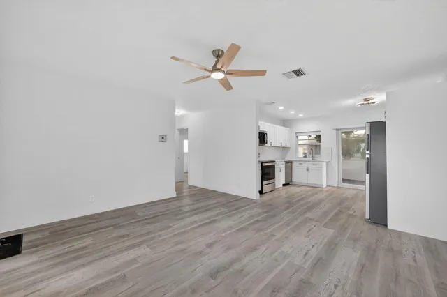 a view of a kitchen with wooden floor and a ceiling fan