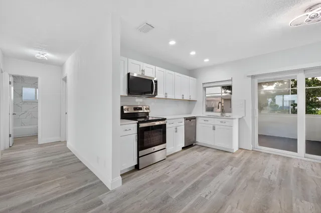 a kitchen with white cabinets and stainless steel appliances