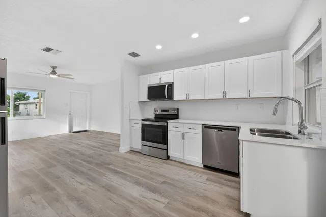 a kitchen with granite countertop a sink and a stove top oven