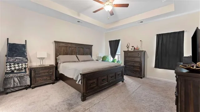 a bedroom with a bed a dresser and a chandelier