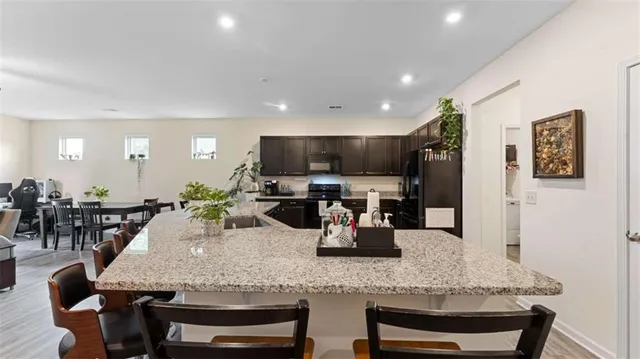 a kitchen with stainless steel appliances granite countertop a refrigerator a stove and a sink