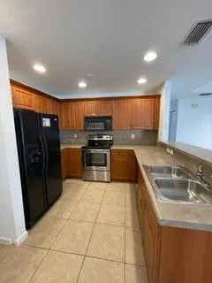a view of a refrigerator in kitchen and a window