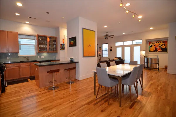an open kitchen with granite countertop a stove a sink a dining table and chairs