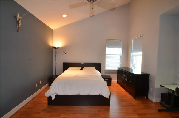 a bedroom with a bed and wooden floor