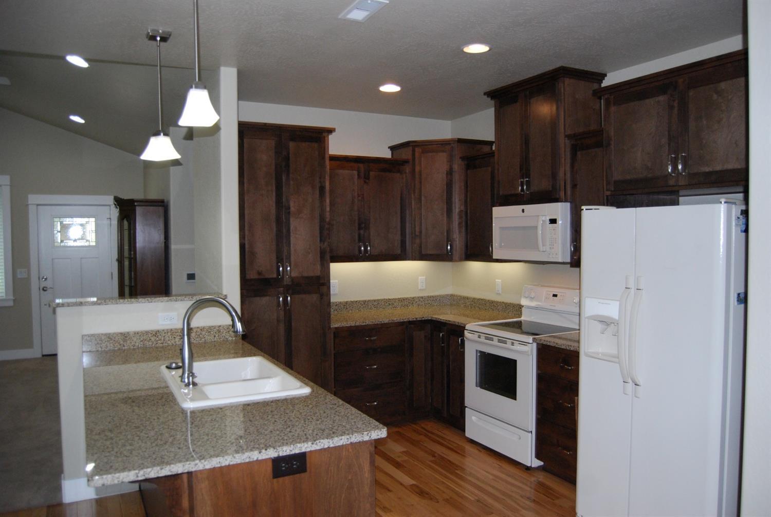 1171 North Haskell Street Central Point, OR 97502 - Photo 7 of 19 a kitchen with a sink a stove and refrigerator
