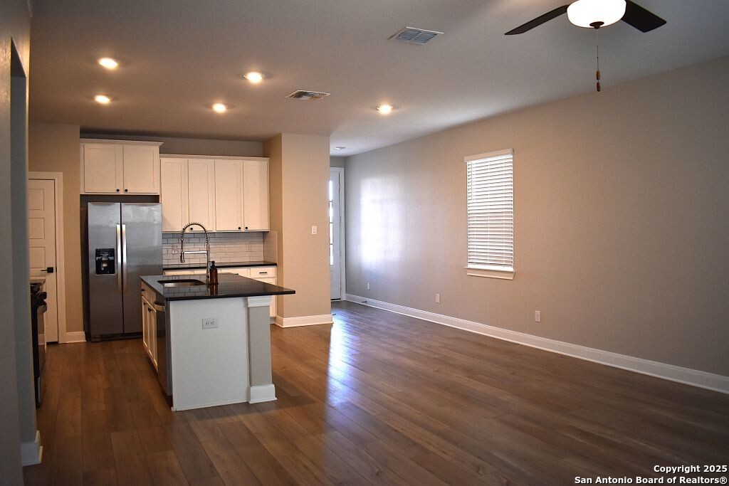 9210 Espadrille Run Converse, TX 78109 - Photo 4 of 17 a kitchen with stainless steel appliances granite countertop a refrigerator a sink dishwasher a stove and white countertops with wooden floor