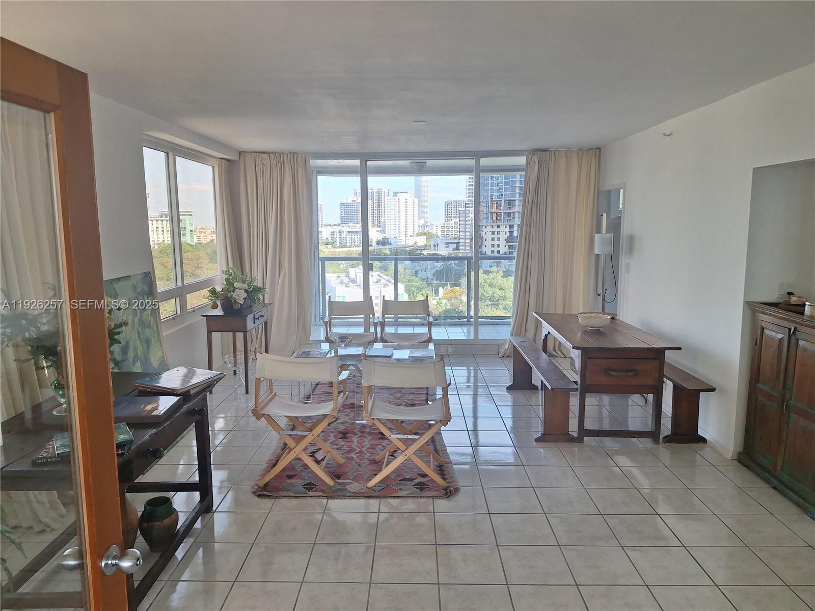 1541 Brickell Avenue, Unit A1201 Miami, FL 33129 - Photo 11 of 17 a living room with furniture a flat screen tv and a floor to ceiling window