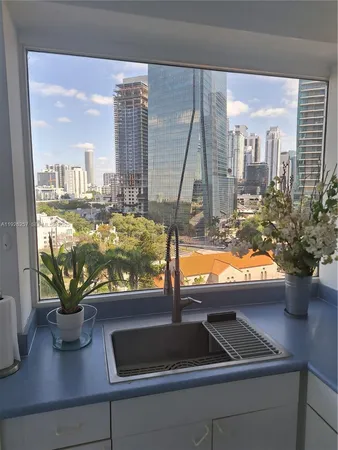 a living room with furniture a flat screen tv and a floor to ceiling window