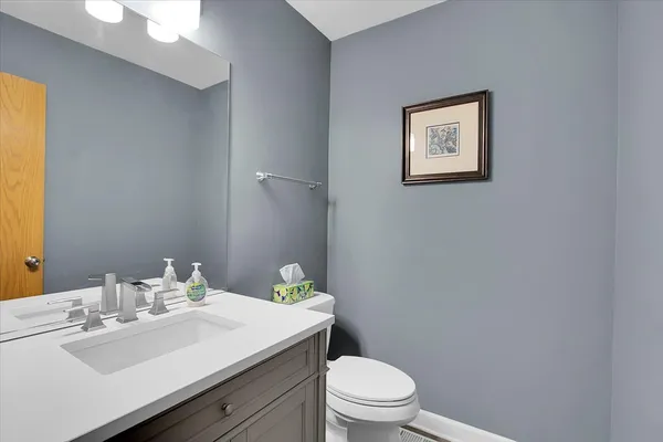a bathroom with a granite countertop toilet sink and mirror
