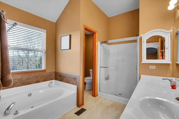 a bathroom with a tub a sink and a large window