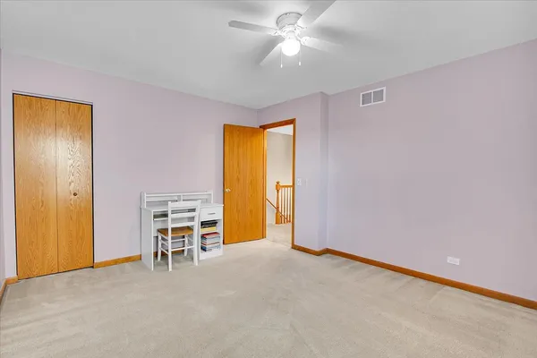 an empty room with a window and a ceiling fan