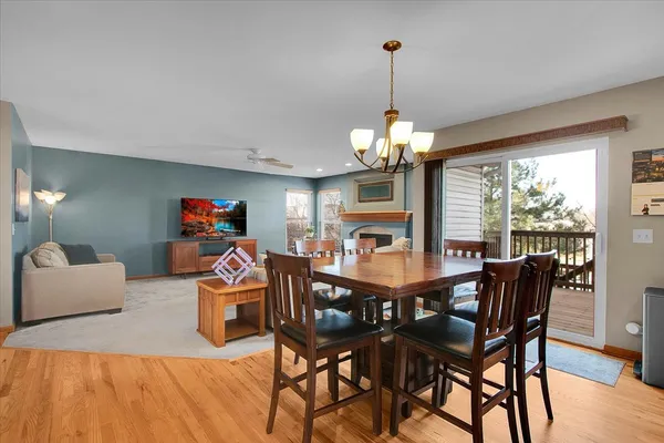 a view of a dining room with furniture a chandelier and wooden floor