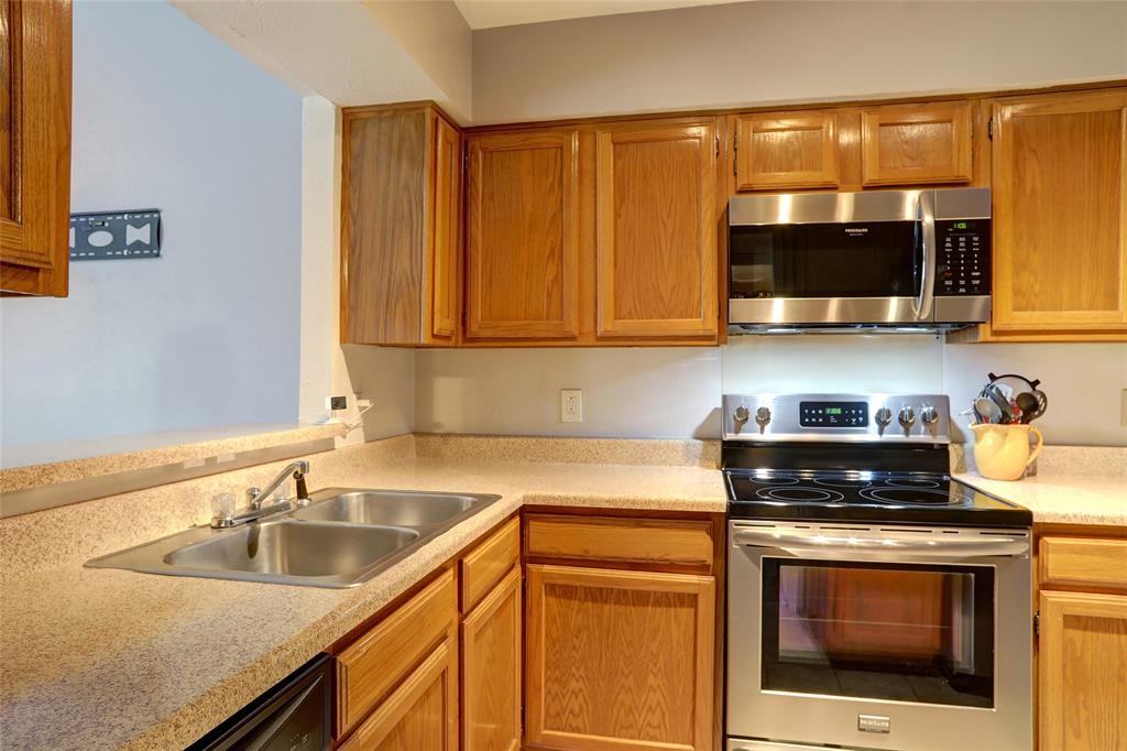 a kitchen with stainless steel appliances granite countertop a sink a stove and a microwave