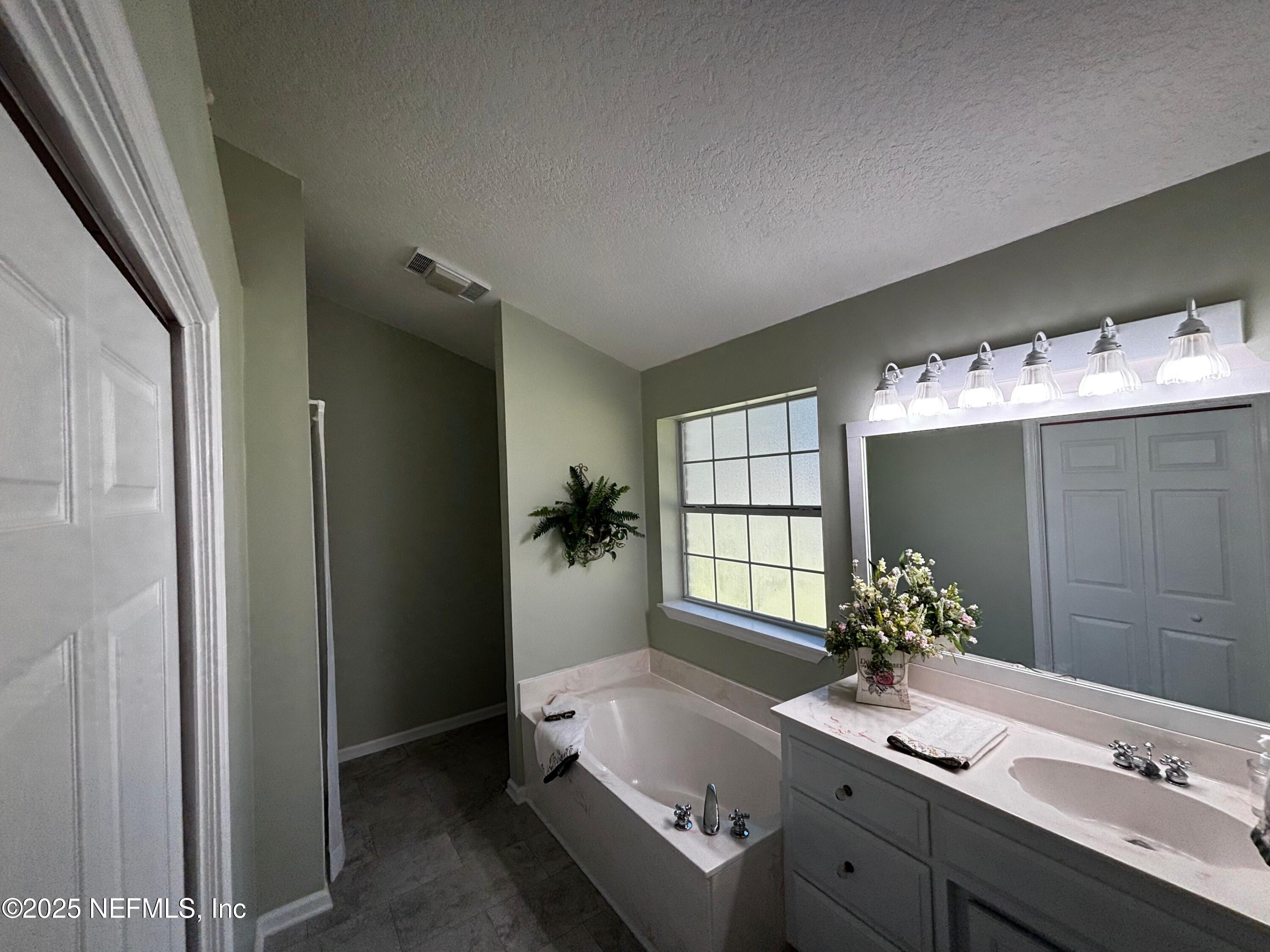 6121 Michele Road Macclenny, FL 32063 - Photo 17 of 26 a bathroom with a tub sink and mirror