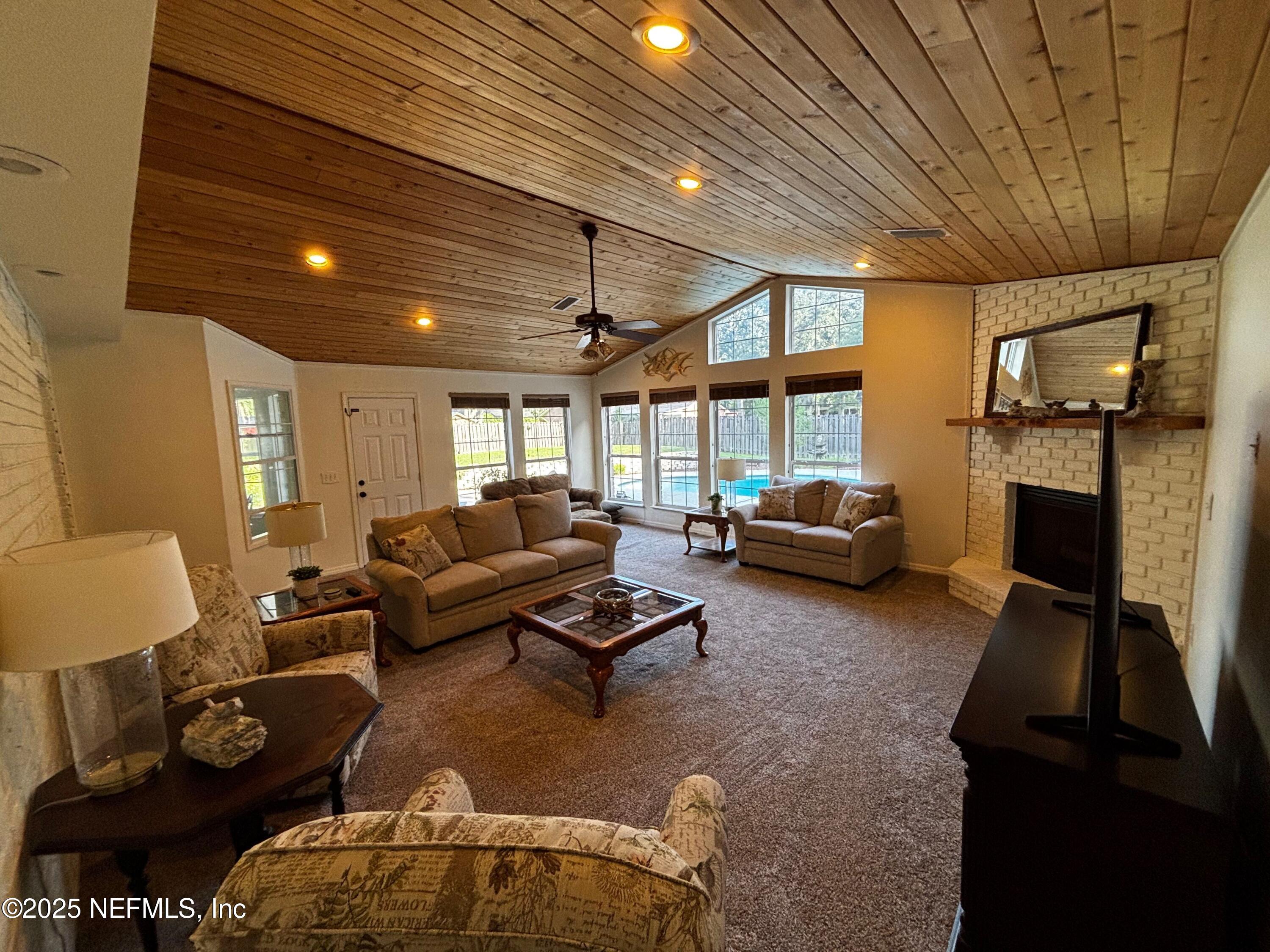 6121 Michele Road Macclenny, FL 32063 - Photo 4 of 26 a living room with furniture a fireplace and a flat screen tv