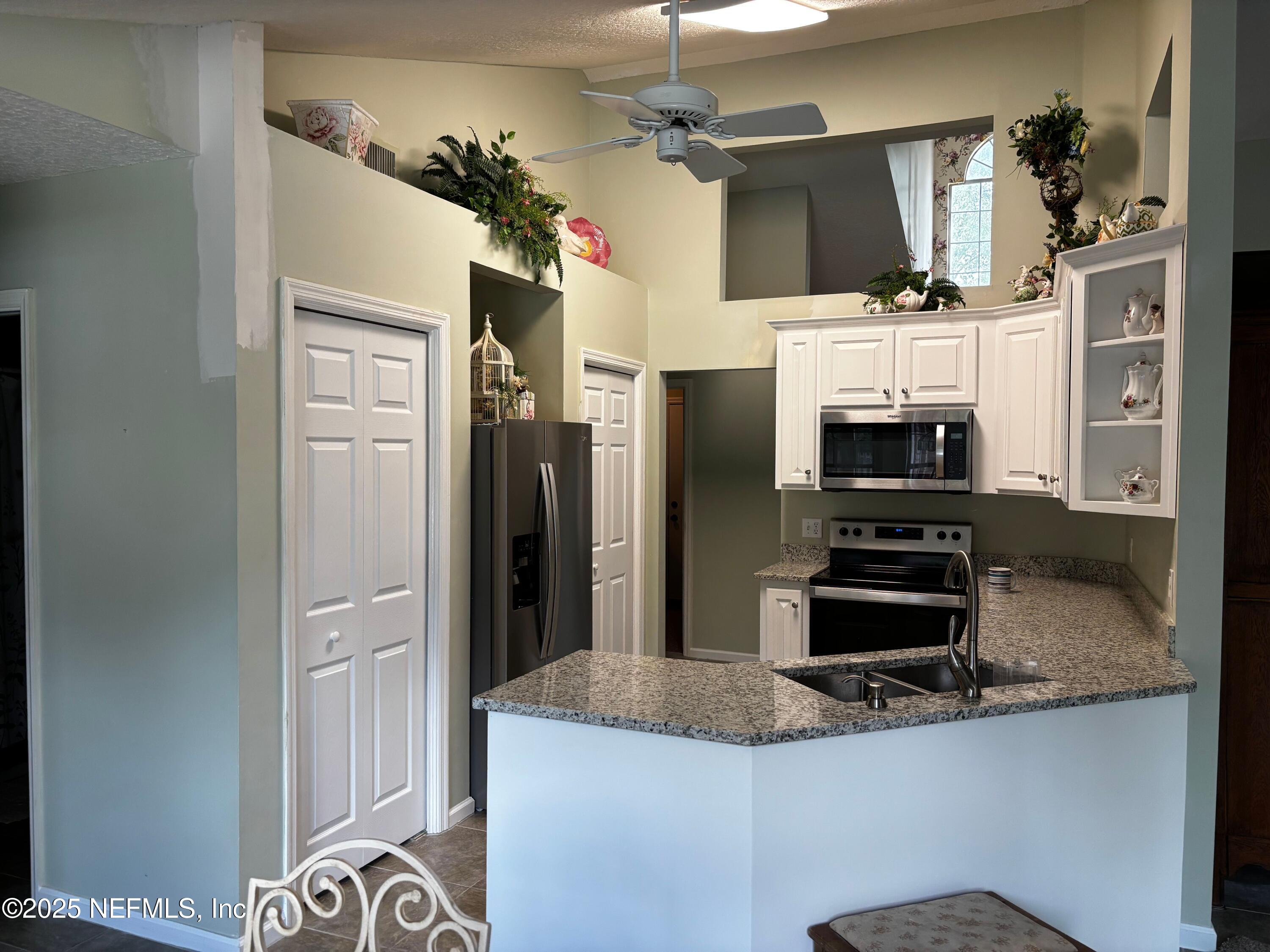 6121 Michele Road Macclenny, FL 32063 - Photo 7 of 26 a kitchen with refrigerator and window
