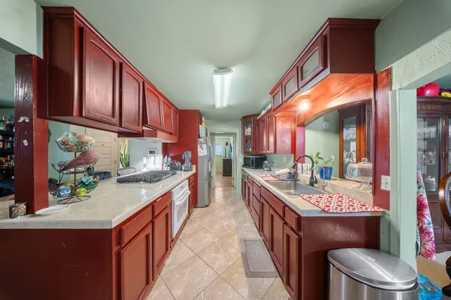 a kitchen with stainless steel appliances granite countertop a stove a sink and a refrigerator