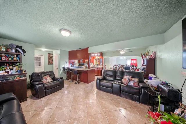 a living room with furniture and a dining table with bookshelf