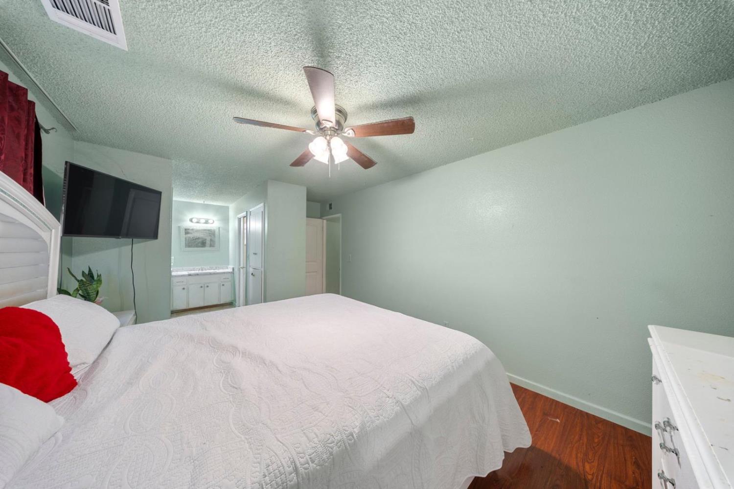 3140 Kellogg Avenue Turlock, CA 95382 - Photo 18 of 22 a bedroom with a large bed and a chandelier