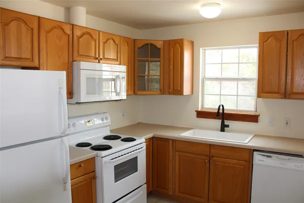 a kitchen with a sink a stove and cabinets