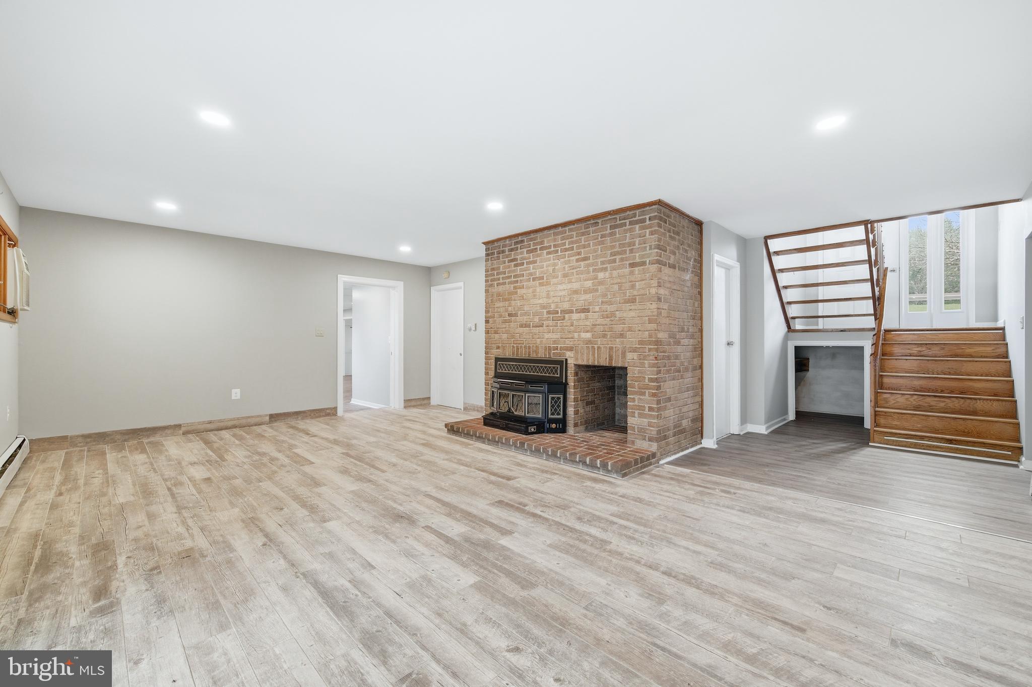 2370 Highway 211 Luray, VA 22835 - Photo 33 of 68 an empty room with wooden floor fireplace and windows