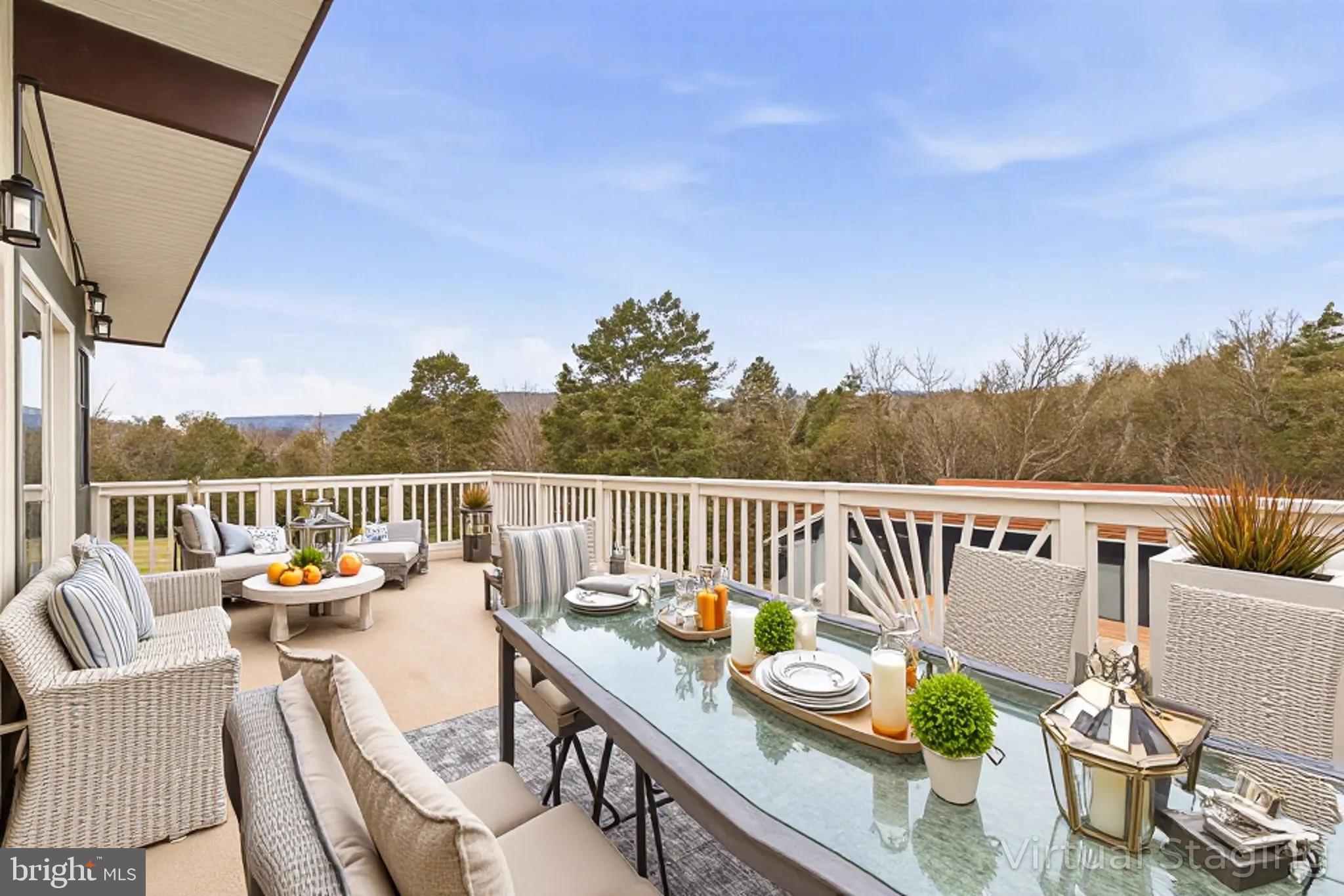 2370 Highway 211 Luray, VA 22835 - Photo 7 of 68 a balcony with couple of couches and potted plants with wooden floor and fence