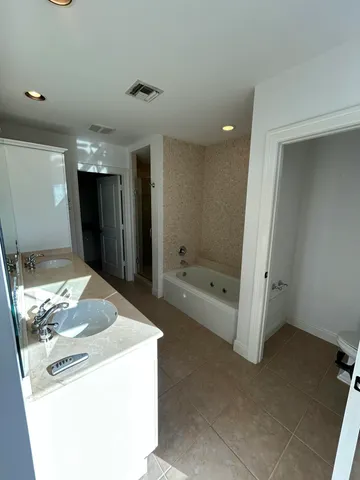 a bathroom with a tub sink and mirror