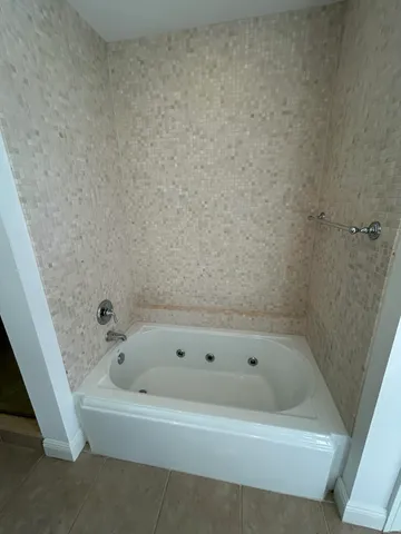 a white bath tub sitting next to a small sink