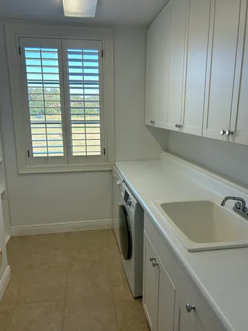 a utility room with a sink dryer and washer