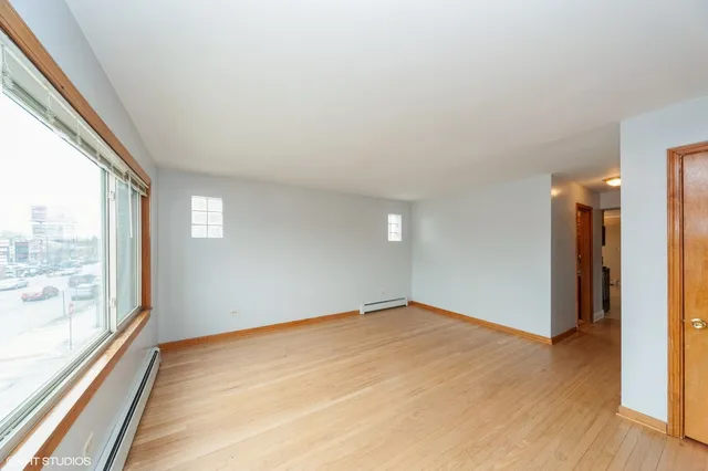 a view of an empty room window and wooden floor