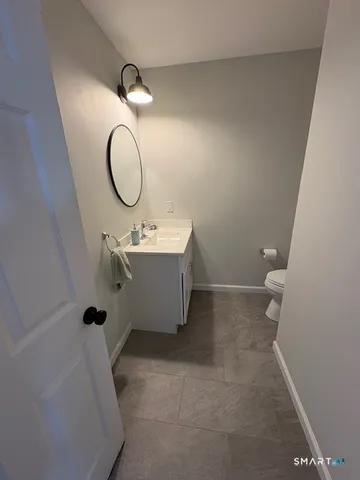a bathroom with a sink mirror and toilet