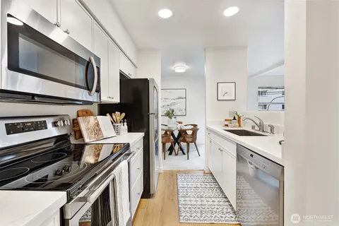 a kitchen with stainless steel appliances granite countertop a refrigerator stove and white cabinets