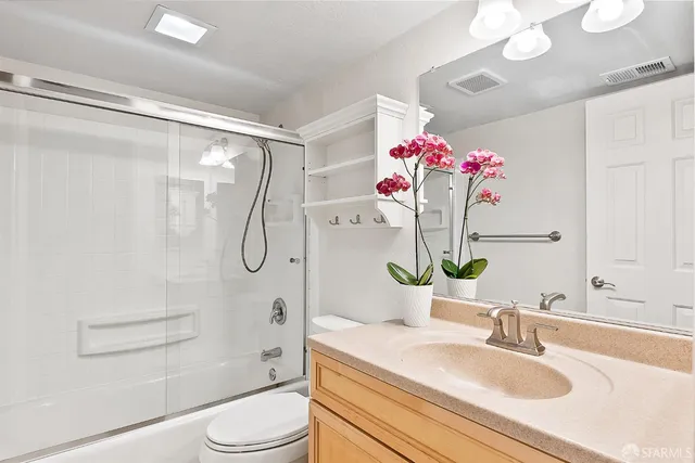 a bathroom with a sink vanity mirror and toilet