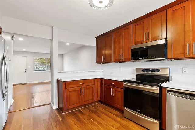 a kitchen with stainless steel appliances a stove a sink and a microwave