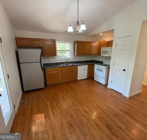 a large kitchen with hardwood floor and a sink