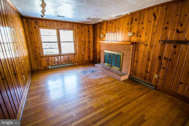 7782 Fort Valley Road Fort Valley, VA 22652 - Photo 15 of 30 wooden floor in an empty room with a fireplace and a window