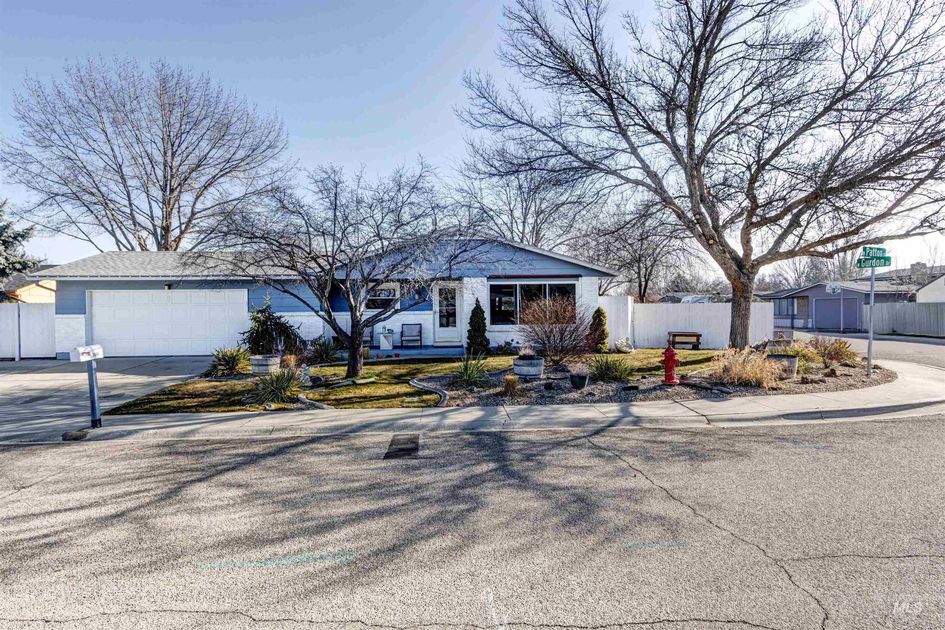 Ranch-style house featuring concrete driveway and an attached garage