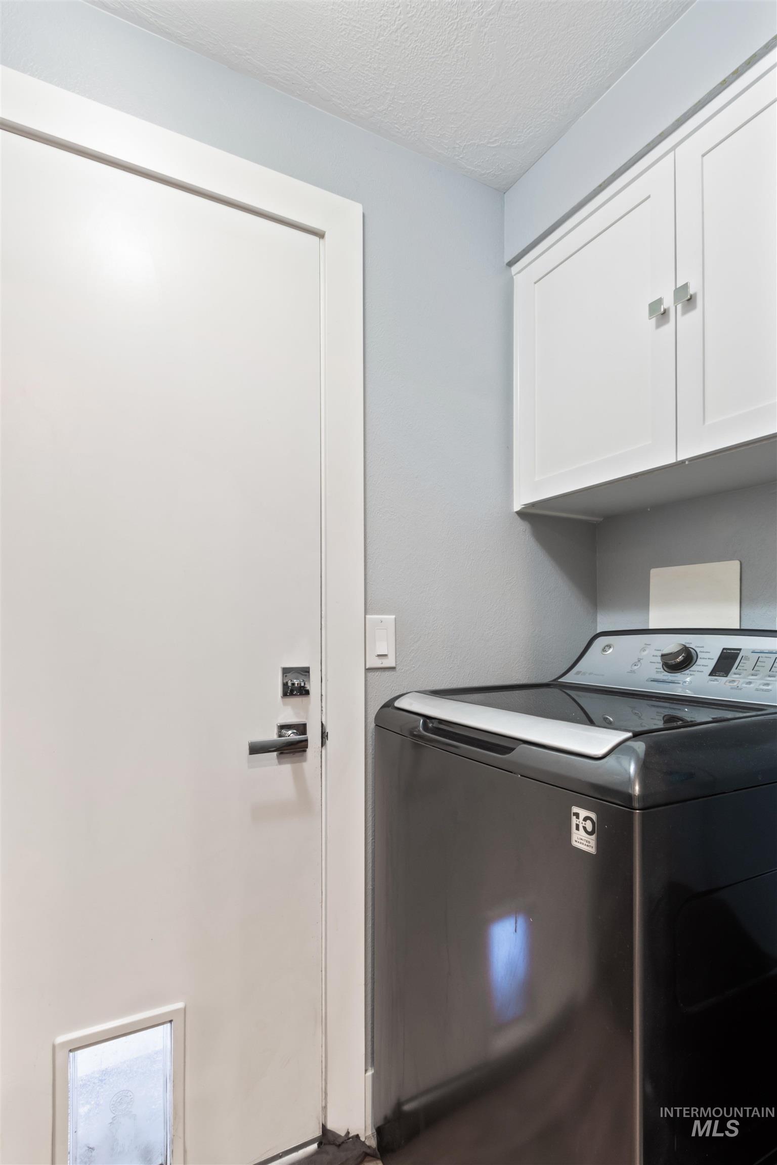 3844 North Patton Street Boise, ID 83704 - Photo 22 of 33 Laundry area featuring washer / dryer, a textured ceiling, and cabinet space