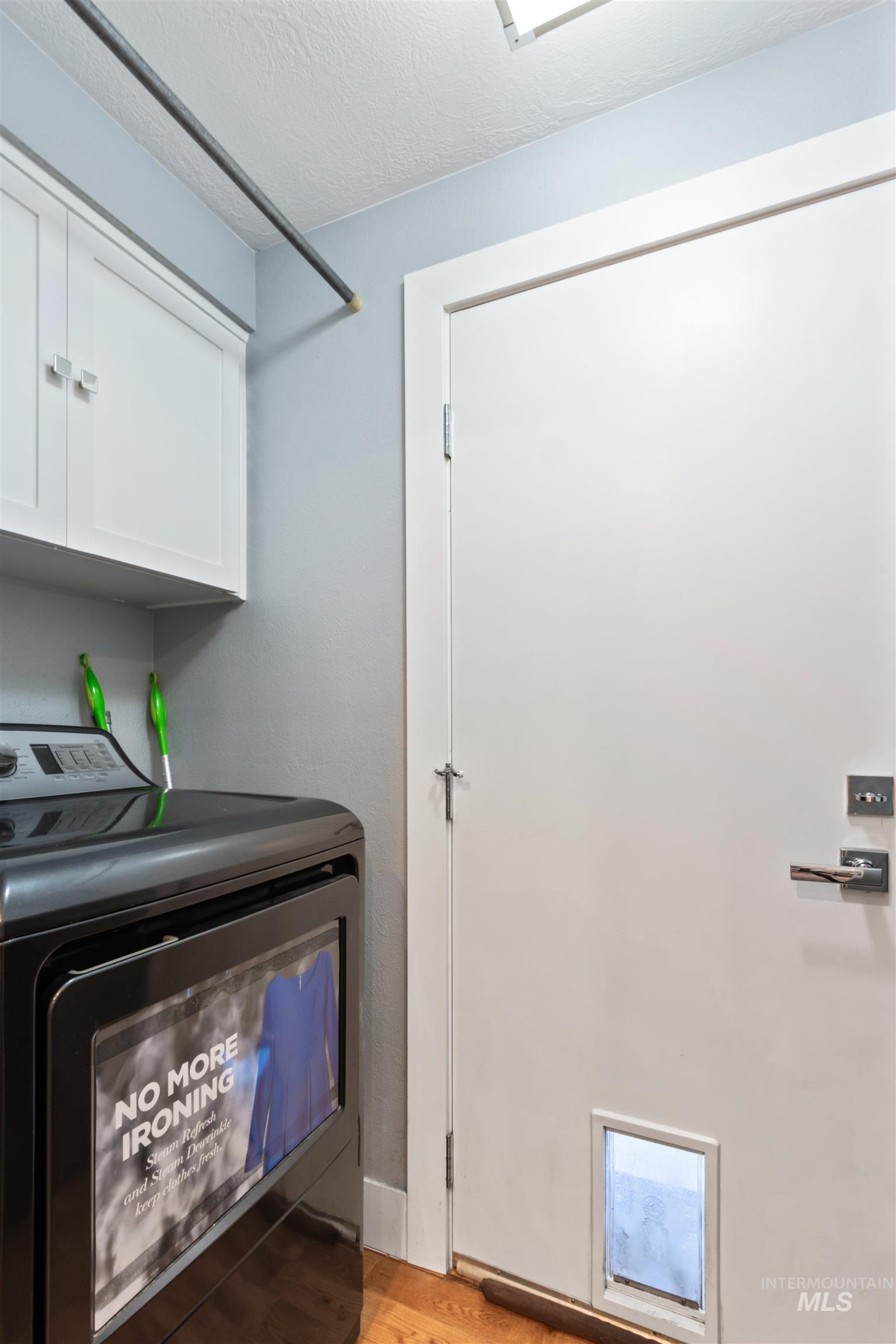 3844 North Patton Street Boise, ID 83704 - Photo 23 of 33 Laundry room with washer / clothes dryer, a textured ceiling, light wood-style flooring, and cabinet space