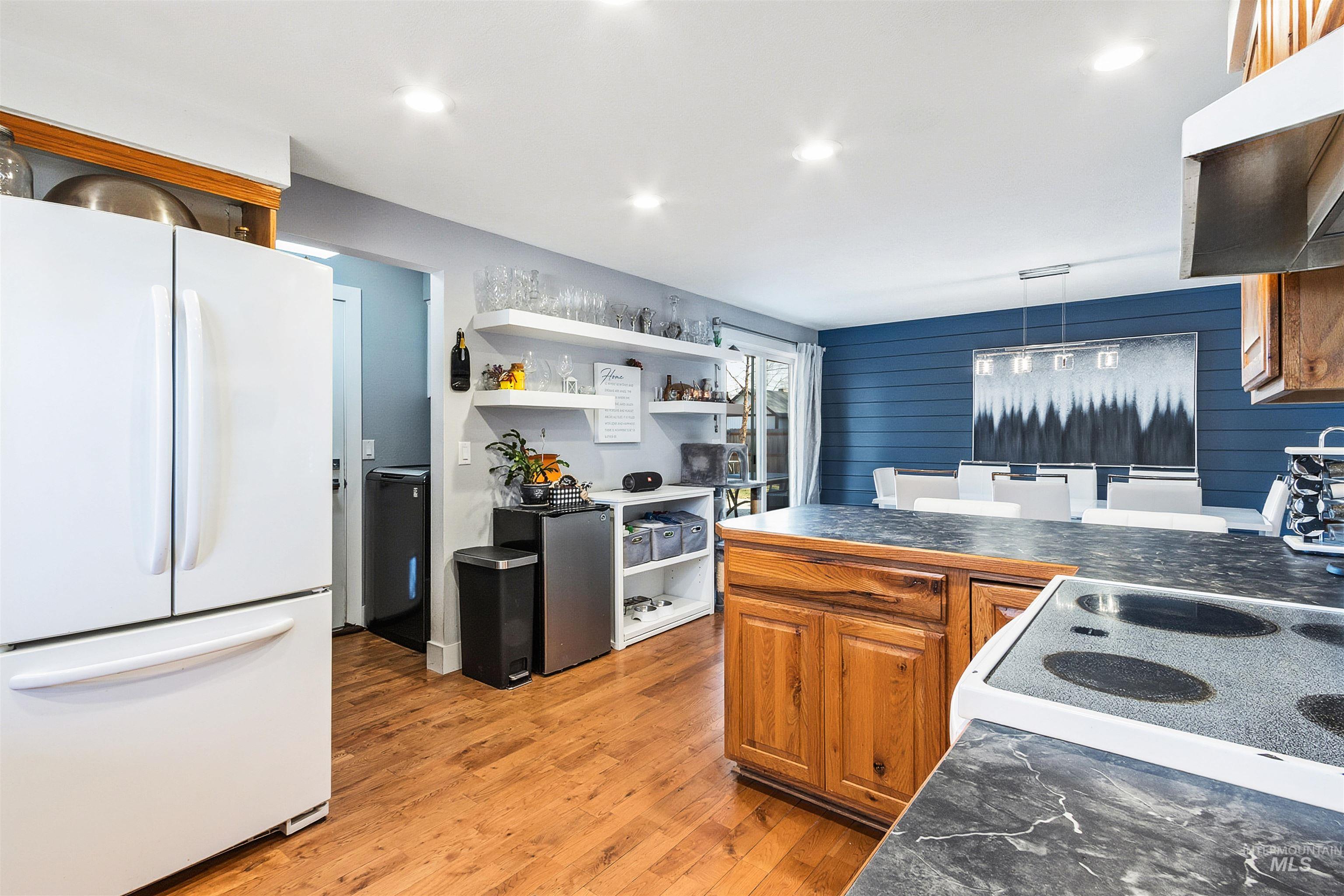 3844 North Patton Street Boise, ID 83704 - Photo 10 of 33 Kitchen with freestanding refrigerator, dark countertops, a peninsula, light wood-style flooring, and wood finish cabinetry