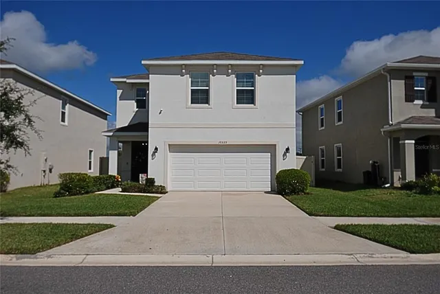 a front view of a house with a yard and garage
