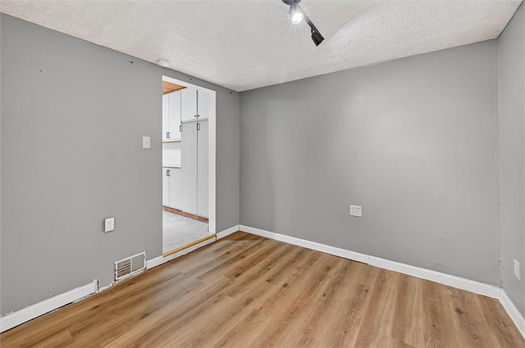 301 Milroy Street Pittsburgh, PA 15214 - Photo 14 of 24 an empty room with wooden floor and windows