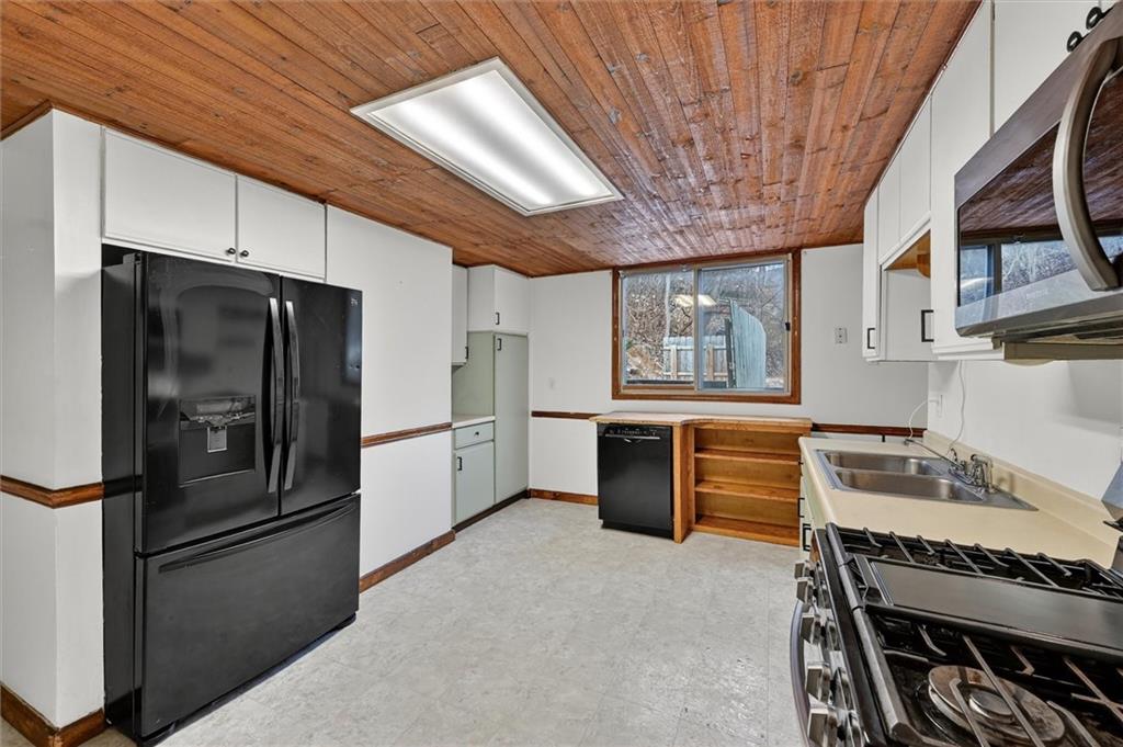 301 Milroy Street Pittsburgh, PA 15214 - Photo 10 of 24 a kitchen with stainless steel appliances granite countertop a refrigerator a sink dishwasher a stove and white countertops with wooden floor