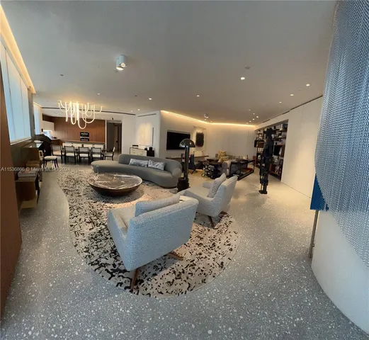 a living room with furniture and floor to ceiling window