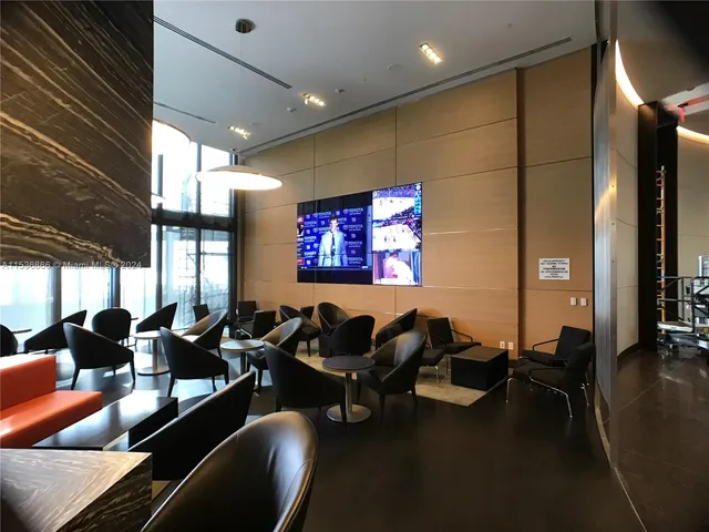 a living room with furniture and floor to ceiling windows