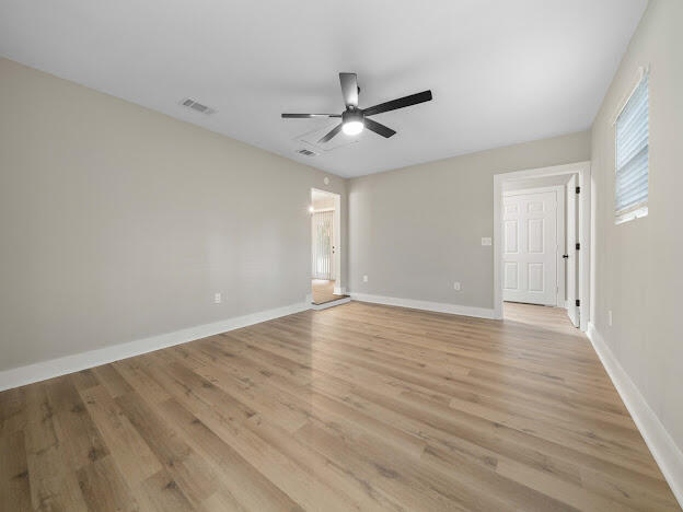 6180 Old Hickory Road Crestview, FL 32539 - Photo 16 of 31 an empty room with wooden floor ceiling fan and windows