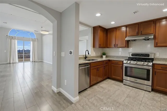 a kitchen with stainless steel appliances kitchen island granite countertop a stove a sink and a refrigerator